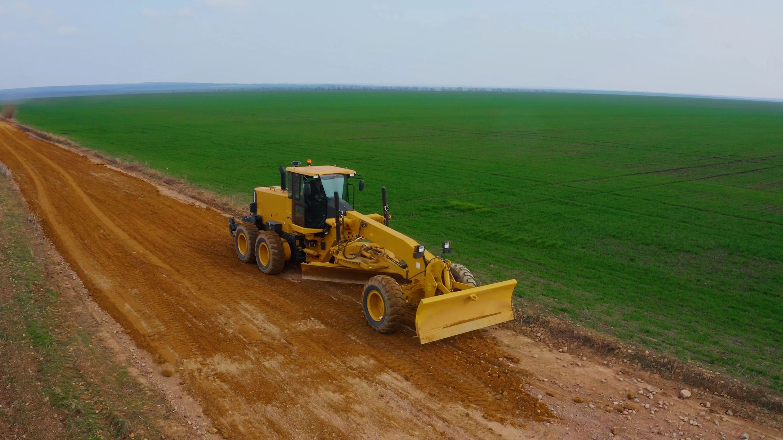 Máquina niveladora atuando em obra de solo